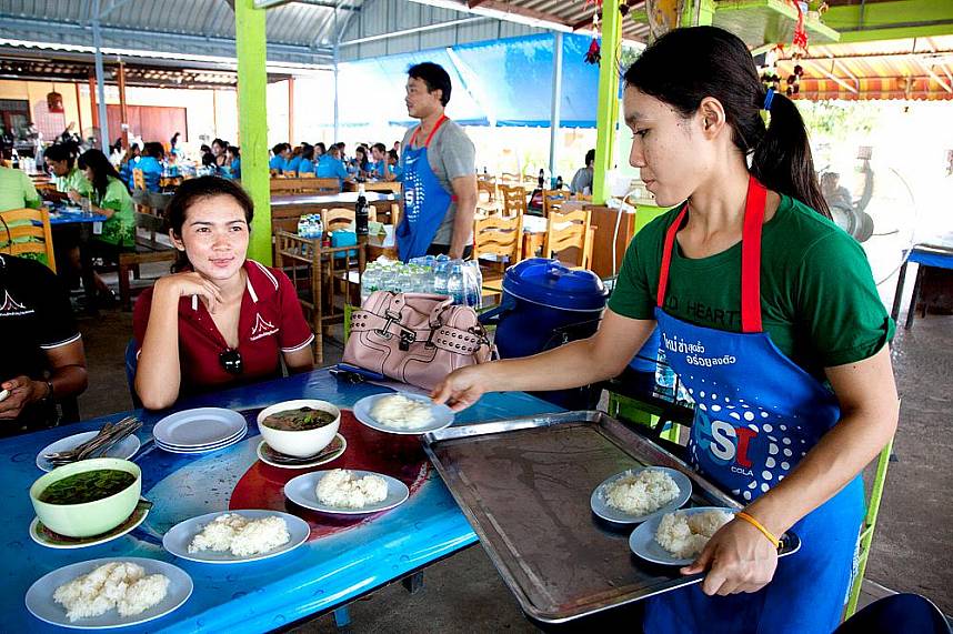 A customer at Pa Mon restaurant in Pattaya get some traditional dishes with Sticky Rice