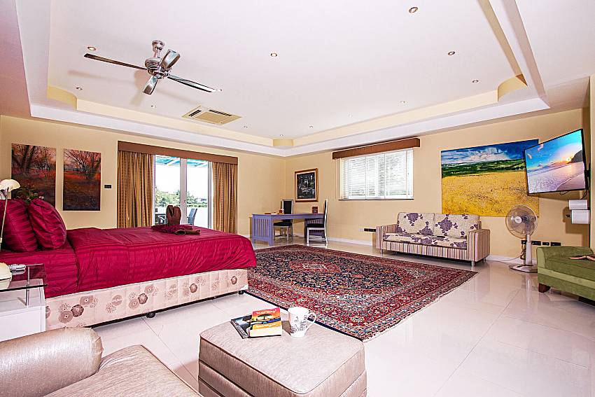 Large bedroom is furnished with sofa and beautiful picture of Pratumnak Argyle Villa (Five)