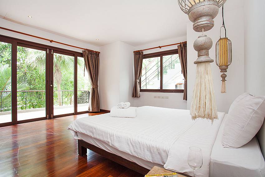 Master bedroom with balcony access at Nirano Villa 31 Phuket