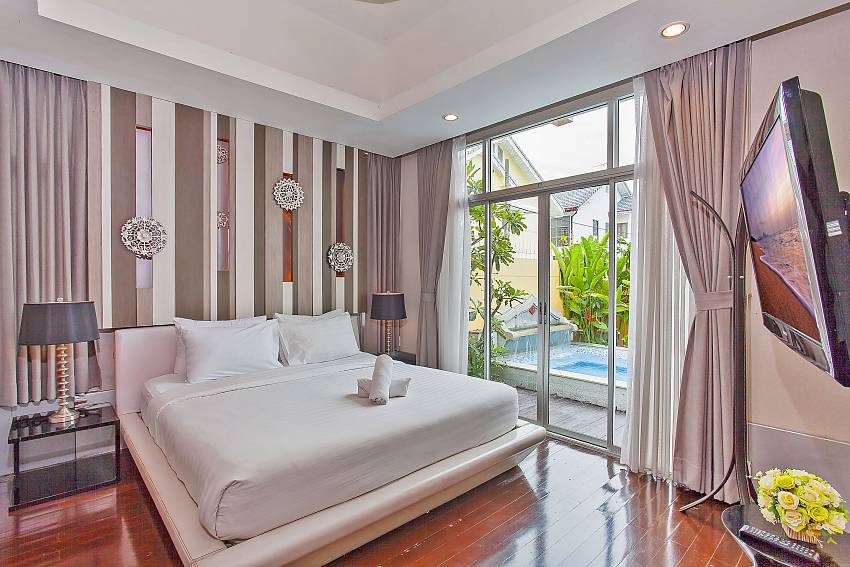 Master bedroom with king-size bed and pool access at Silver Sky Villa Pattaya