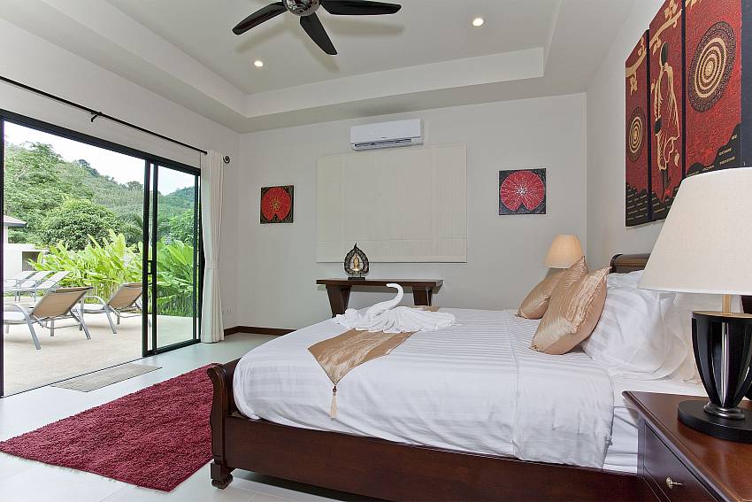 Master bedroom with king-size bed and pool access at Tub Tim Villa Phuket